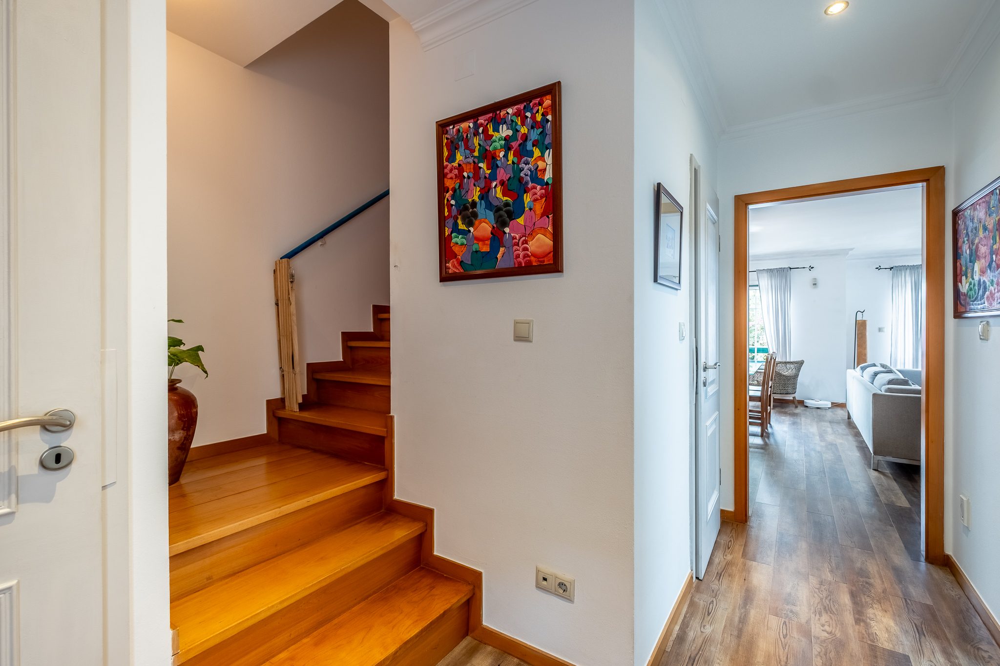 Hall de entrada de 5,80 m² com a escada interior em madeira que sobe para o piso dos quartos