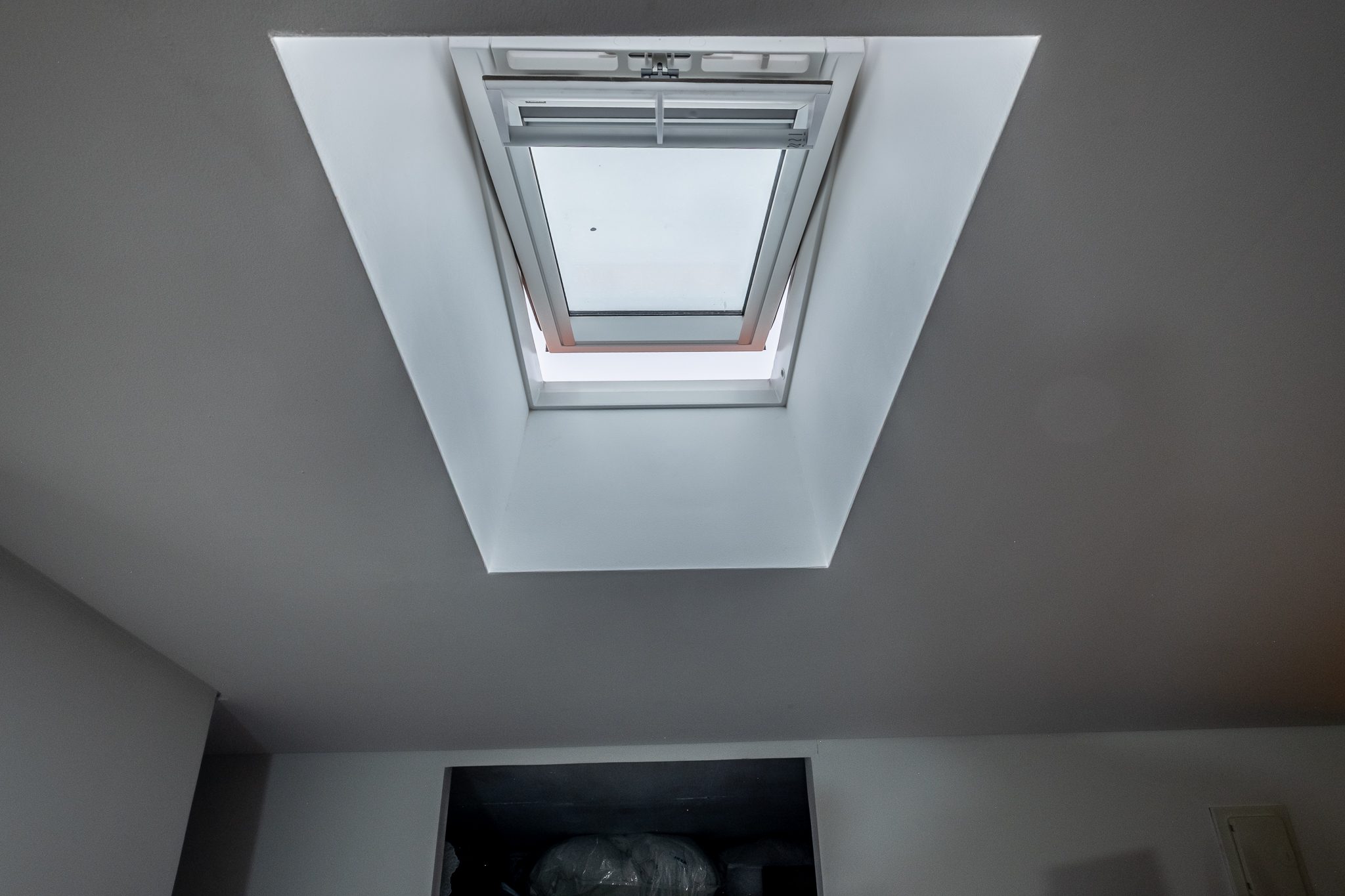 Janela Velux na cobertura inclinada, vista de baixo, em posição de ventilação