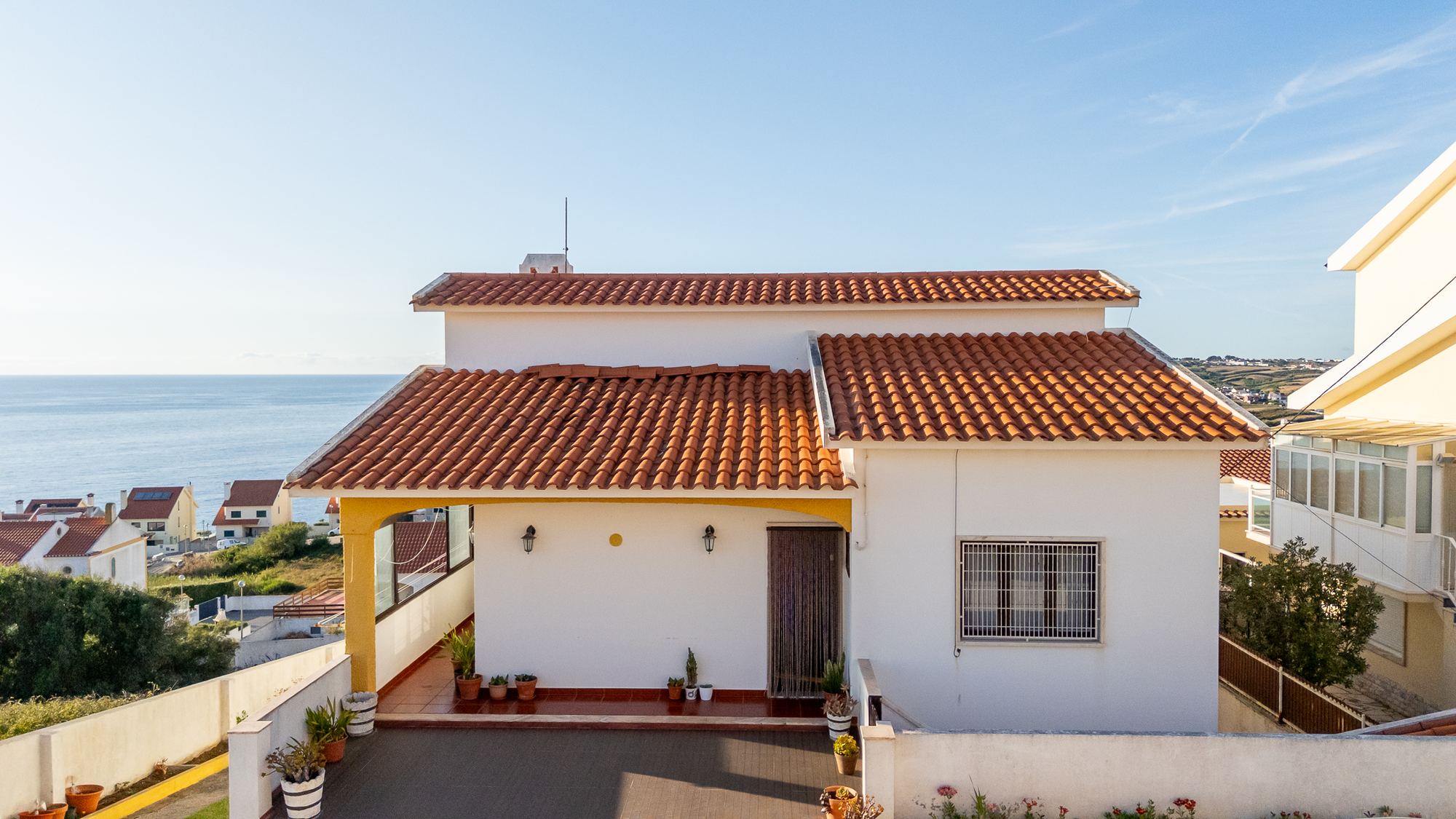 Fachada da moradia com entrada coberta e vista mar