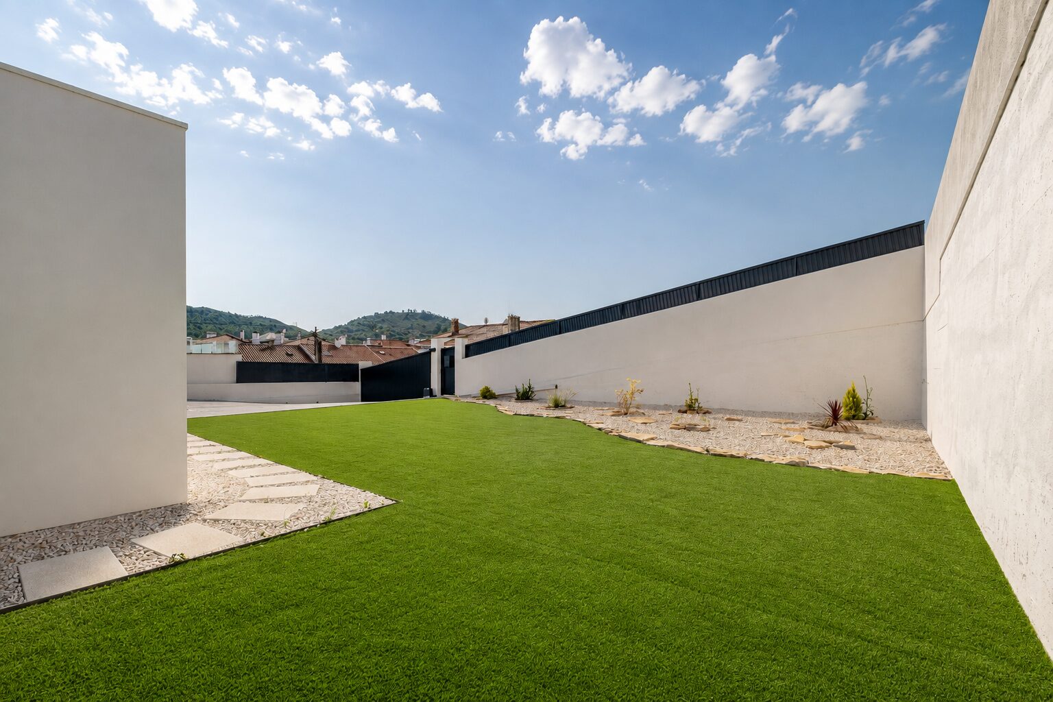 Relvado lateral contínuo, sem desníveis, junto ao muro do lote